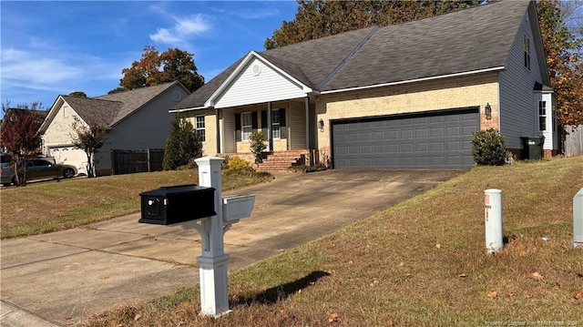 single story home with a porch, a front yard, and a garage