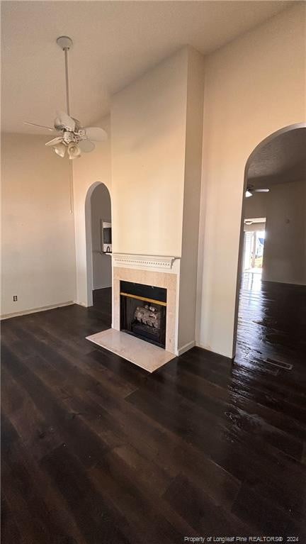 unfurnished living room with dark wood-type flooring and ceiling fan