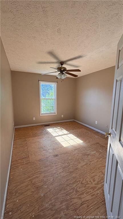 spare room with a textured ceiling, hardwood / wood-style flooring, and ceiling fan