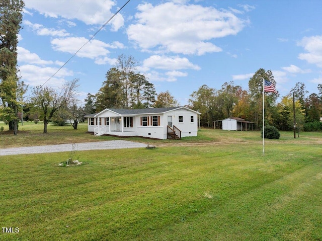 view of front of property featuring a front lawn, a storage shed, and covered porch