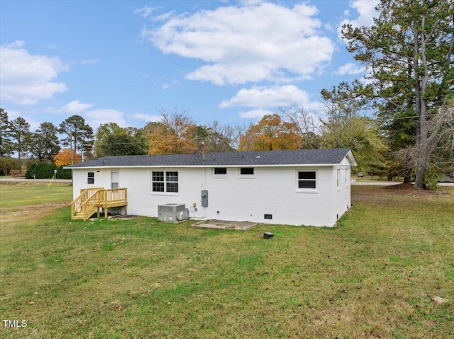 rear view of house with a lawn and central AC unit