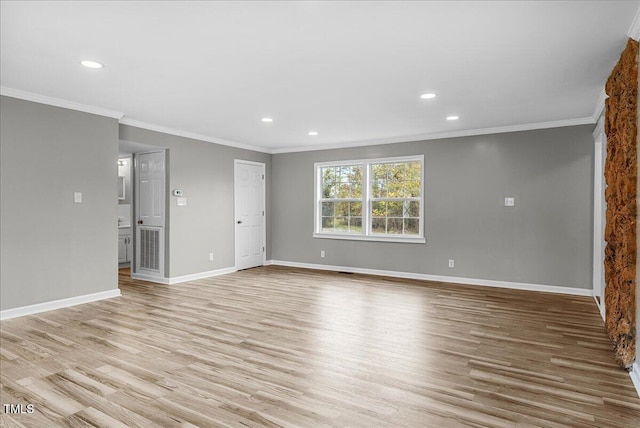 empty room with crown molding and light hardwood / wood-style flooring