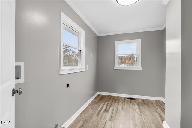 laundry area featuring light hardwood / wood-style floors, hookup for an electric dryer, a healthy amount of sunlight, and crown molding