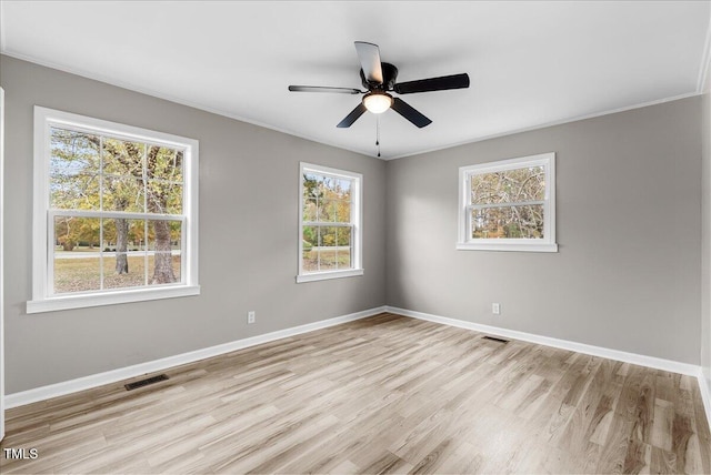 spare room with ceiling fan, ornamental molding, and light wood-type flooring