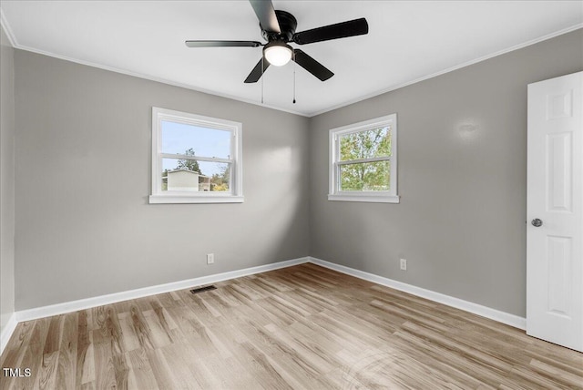 empty room with ceiling fan, a healthy amount of sunlight, ornamental molding, and light wood-type flooring