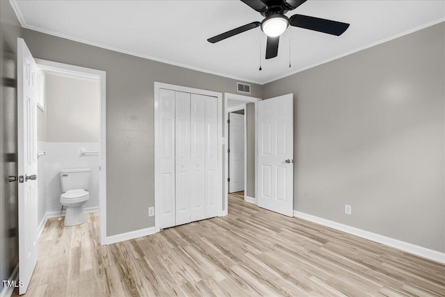 unfurnished bedroom with a closet, ceiling fan, light hardwood / wood-style floors, tile walls, and ornamental molding