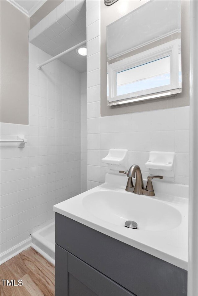 bathroom with vanity, tile walls, walk in shower, and hardwood / wood-style floors