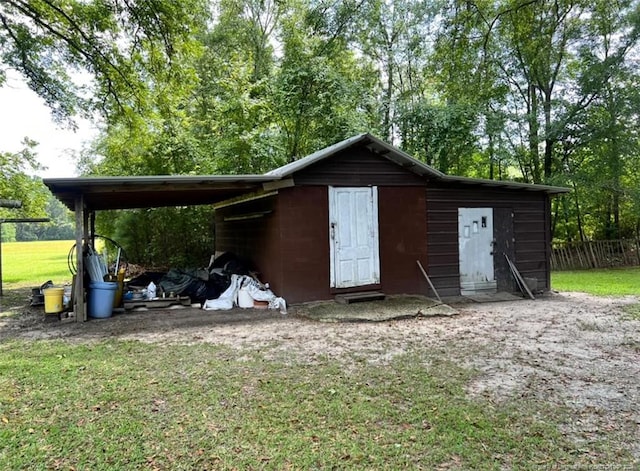 view of outdoor structure featuring a yard and a carport