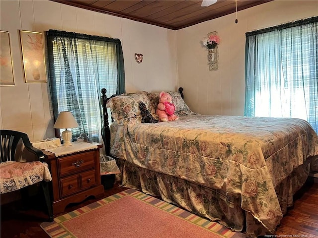 bedroom with dark wood-type flooring, crown molding, and wooden ceiling