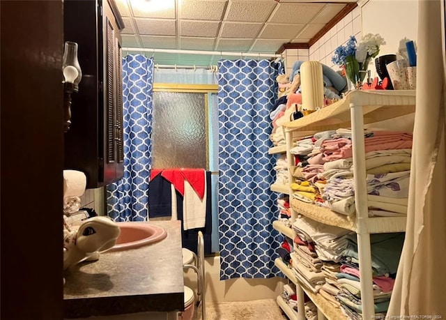 bathroom with vanity, a paneled ceiling, and toilet