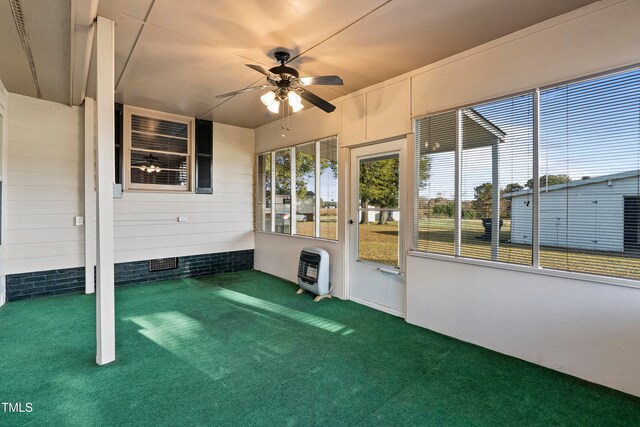 unfurnished sunroom with ceiling fan and heating unit