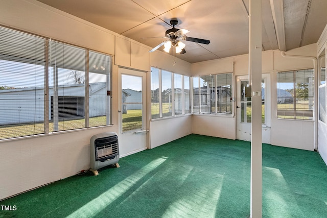 unfurnished sunroom with ceiling fan and heating unit