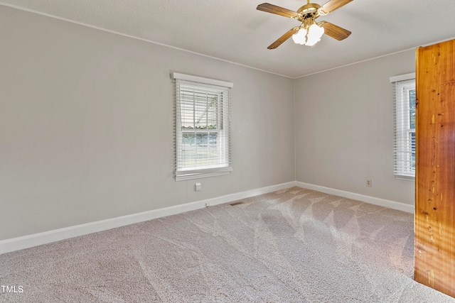 spare room featuring ceiling fan and carpet floors