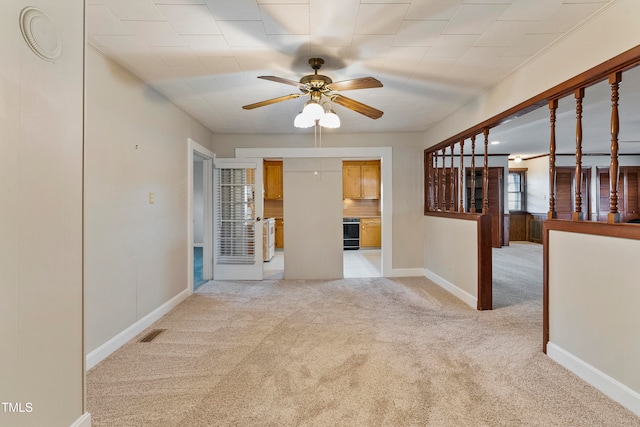 spare room with light colored carpet and ceiling fan