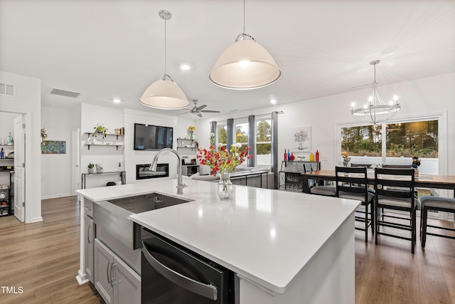 kitchen with black dishwasher, a sink, a chandelier, recessed lighting, and light countertops