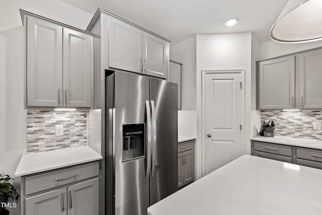kitchen with stainless steel fridge with ice dispenser, gray cabinets, light countertops, and recessed lighting