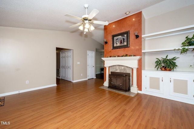 unfurnished living room featuring hardwood / wood-style floors, ceiling fan, lofted ceiling, and a textured ceiling