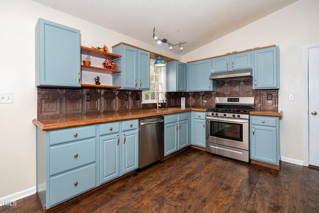 kitchen featuring blue cabinetry, appliances with stainless steel finishes, and lofted ceiling