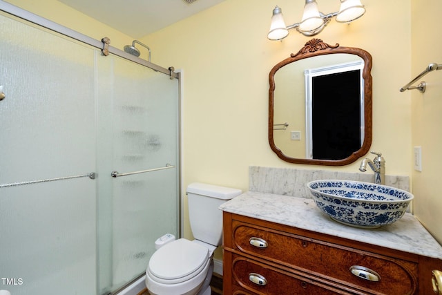 bathroom featuring vanity, an enclosed shower, and toilet