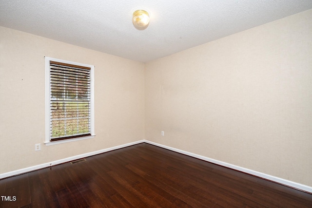 empty room featuring a textured ceiling and hardwood / wood-style flooring