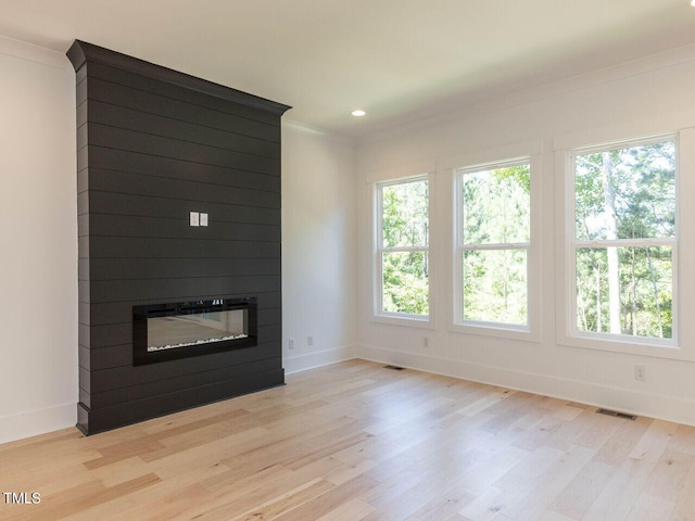 103 Brandy Ml, Pittsboro, NC 27312 - unfurnished living room with baseboards, light wood finished floors, a large fireplace, recessed lighting, and ornamental molding
