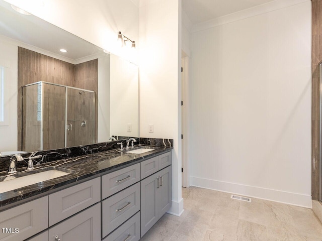 bathroom featuring vanity, crown molding, and a shower with shower door