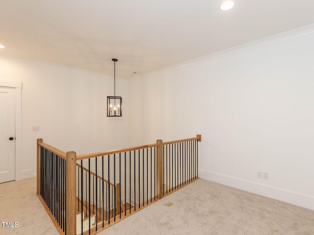 hall featuring light colored carpet, an inviting chandelier, and crown molding