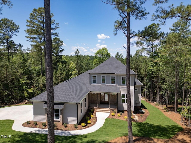103 Brandy Ml, Pittsboro, NC 27312 - view of front facade with a front lawn, a shingled roof, a wooded view, and a porch
