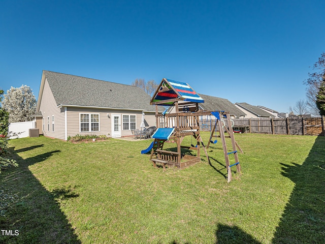 rear view of house with a yard and a playground