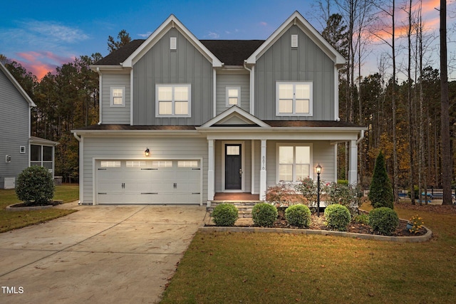 view of front of house featuring a lawn, a porch, and a garage