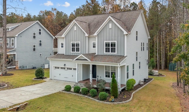 view of front of house featuring covered porch, a garage, and a front yard