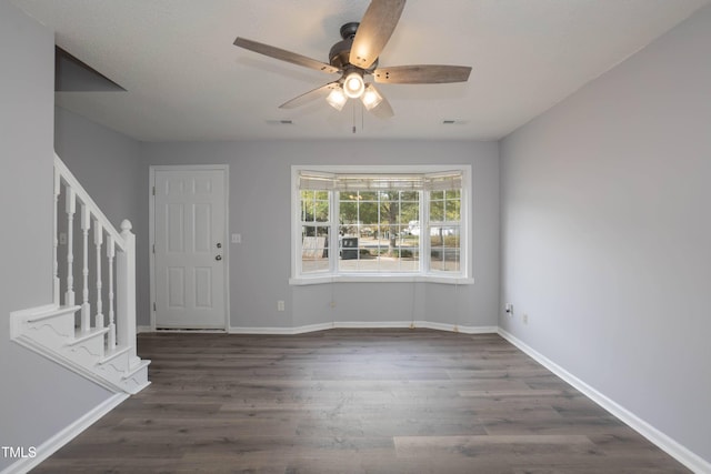 entrance foyer featuring a textured ceiling, ceiling fan, and dark wood-type flooring