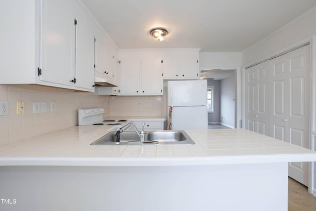 kitchen with white cabinetry, sink, white appliances, and kitchen peninsula