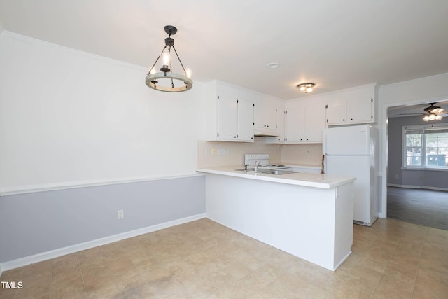 kitchen with kitchen peninsula, white appliances, crown molding, pendant lighting, and white cabinets