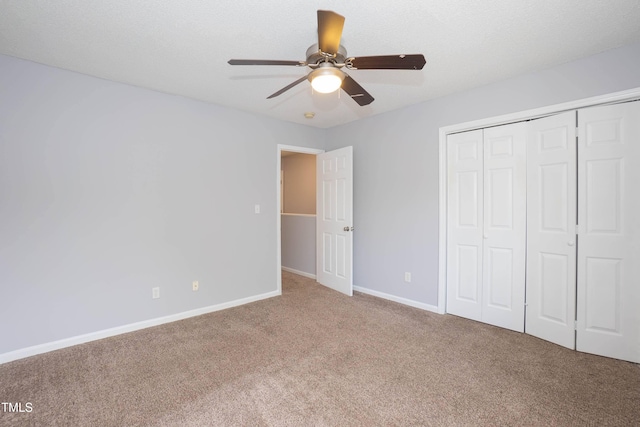 unfurnished bedroom featuring carpet, ceiling fan, a textured ceiling, and a closet