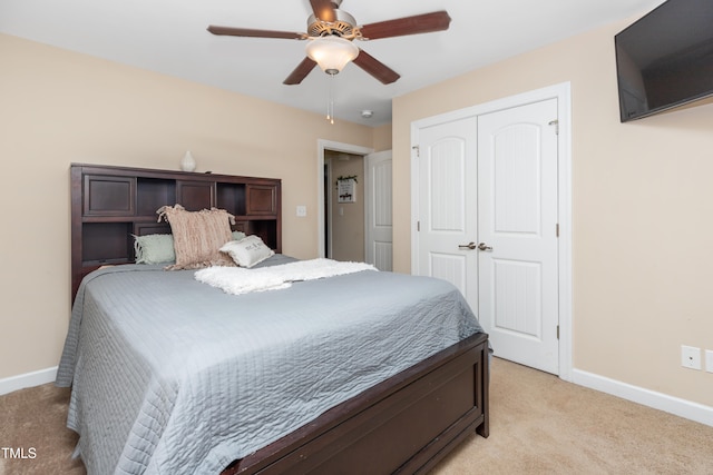 bedroom with ceiling fan, a closet, and light colored carpet