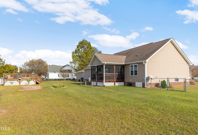 rear view of house with central AC, a sunroom, and a lawn