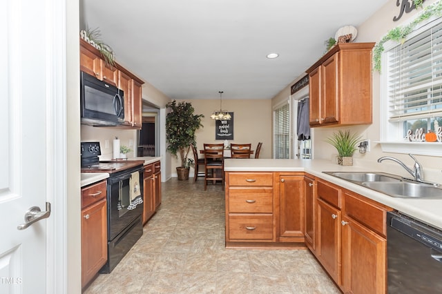 kitchen featuring hanging light fixtures, sink, black appliances, and kitchen peninsula