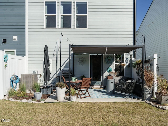 rear view of house featuring a patio, cooling unit, and a yard