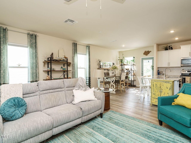 living room featuring sink and light hardwood / wood-style floors