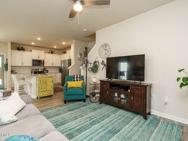 living room featuring hardwood / wood-style flooring and ceiling fan