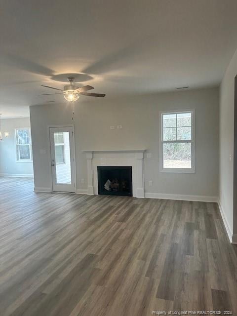 unfurnished living room with ceiling fan and dark wood-type flooring