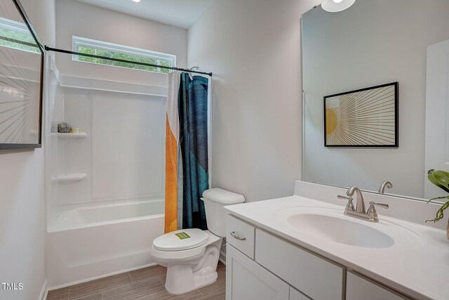 full bathroom with toilet, hardwood / wood-style floors, shower / bath combo with shower curtain, and vanity