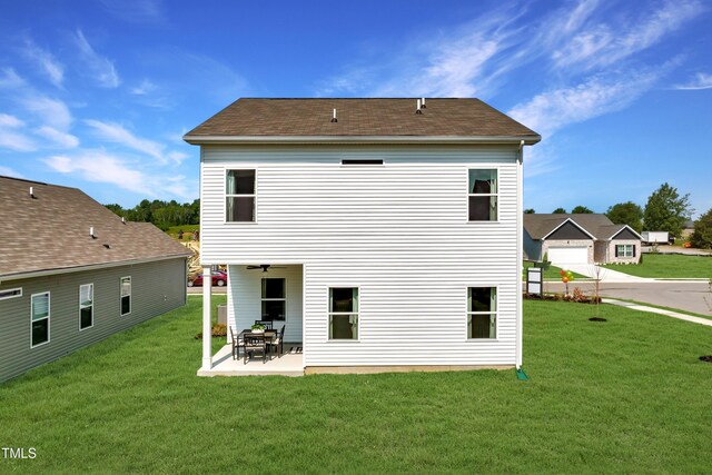 back of house with a patio area, a garage, and a lawn