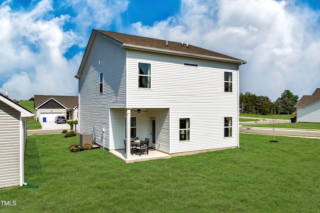 rear view of house featuring a garage, a yard, cooling unit, and a patio area