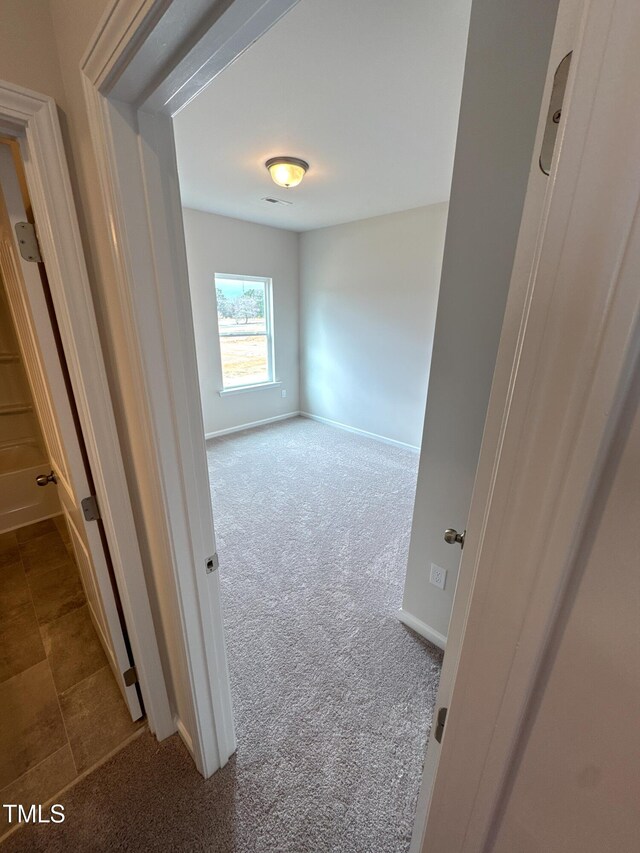 corridor with carpet floors and baseboards