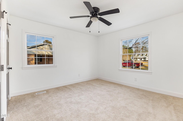 spare room featuring light colored carpet and ceiling fan