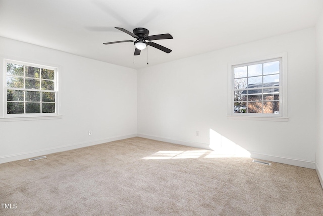 carpeted spare room with ceiling fan