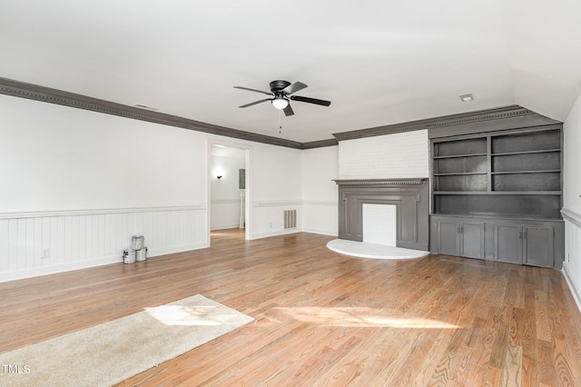 unfurnished living room featuring built in shelves, crown molding, ceiling fan, and wood-type flooring