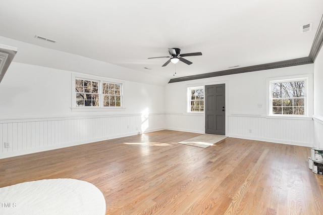 interior space with light wood-type flooring, plenty of natural light, ornamental molding, and ceiling fan